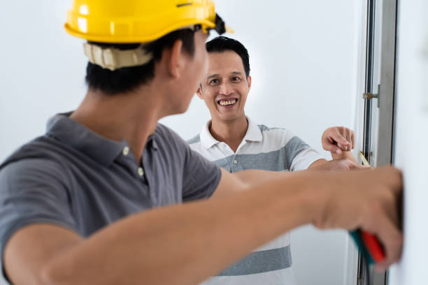 istock Foreman with safety helmet measuring a window frame with tape measure while working on a new home improvement project. 1385021200
