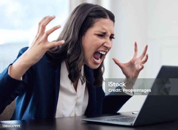 Shot Of A Young Businesswoman Yelling While Using A Laptop In An Office At Work Stock Photo - Download Image Now