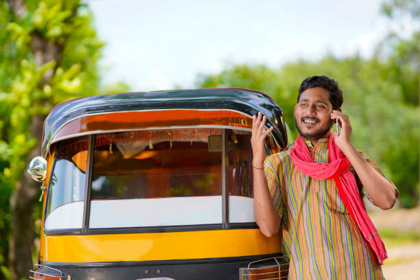 indyjski kierowca trójkołowej rikszy mówi na smartfonie. - autorick zdjęcia i obrazy z banku zdjęć