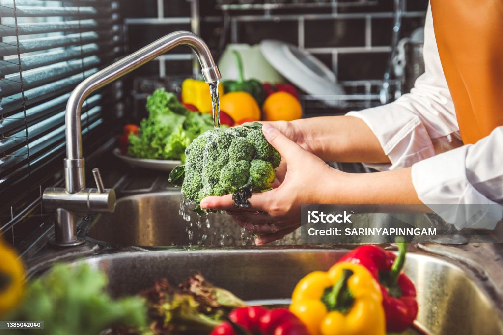 Hand of maid washing tomato fresh vegetables preparation healthy food in kitchen Vegetable Stock Photo