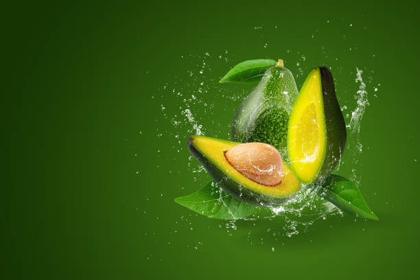 istock Water splashing on Green ripe avocado on a green background. 1385042307