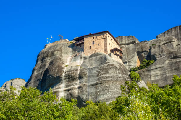 istock Greek Monastery on a Rock Against the Blue Sky 1385044779