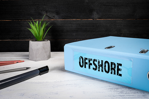 Offshore. Tax savings and revenue concealment concept. Document folder on office desk.