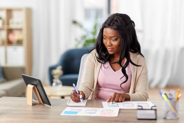 african woman working on ui design at home office stock photo