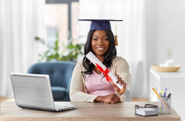 istock graduate student with laptop and diploma at home 1385049810