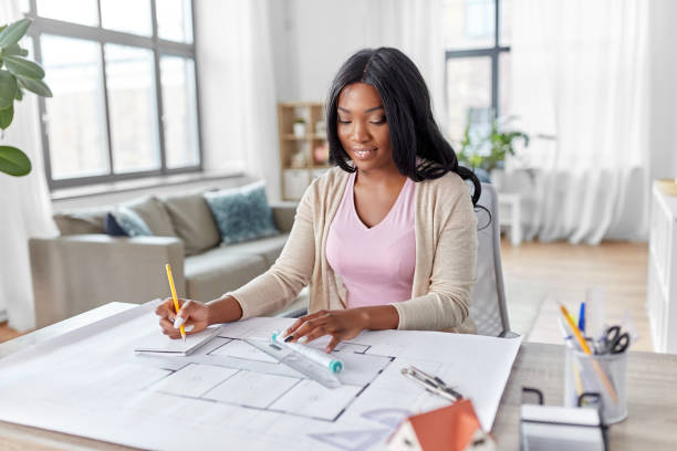 istock female architect with house model and blueprint 1385050739