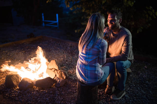 istock Romantic couple talking by the bonfire in the backyard at night. 1385050745