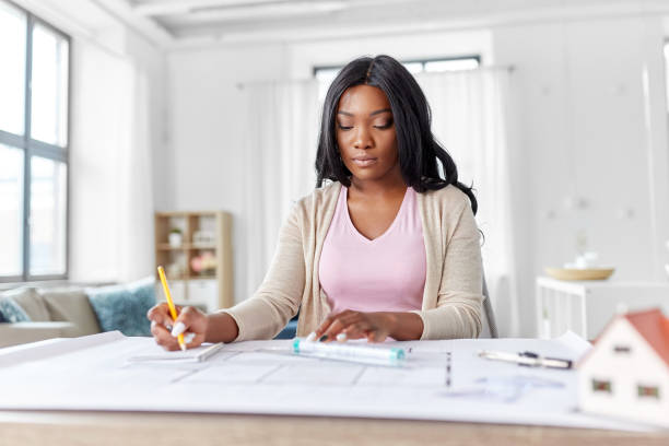 istock female architect with house model and blueprint 1385050750