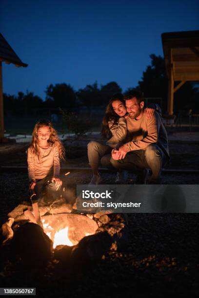 Happy Family Enjoying By The Bonfire In The Backyard At Night Stock Photo - Download Image Now