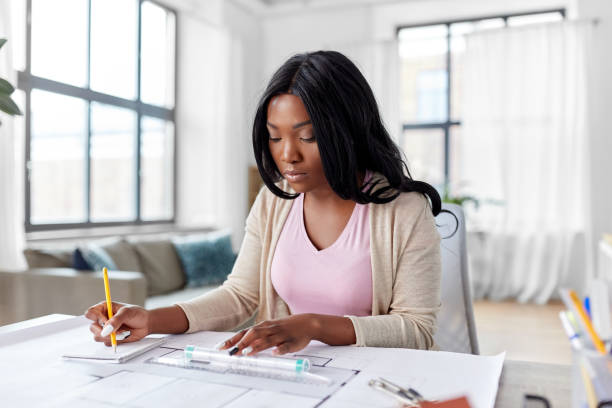 istock female architect with house model and blueprint 1385051813