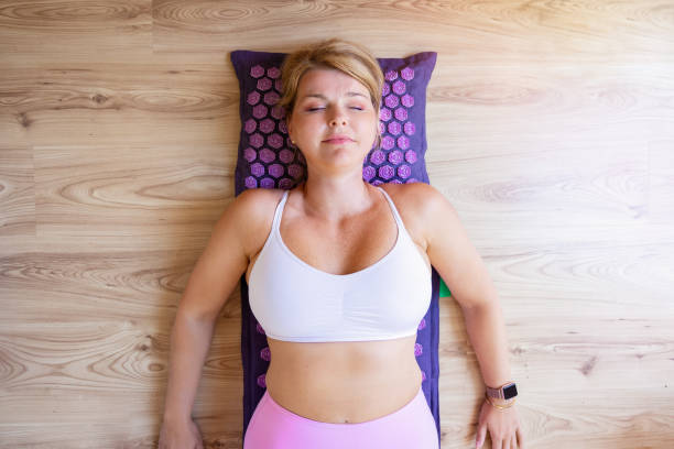 istock Woman lying on acupressure mat 1385054100