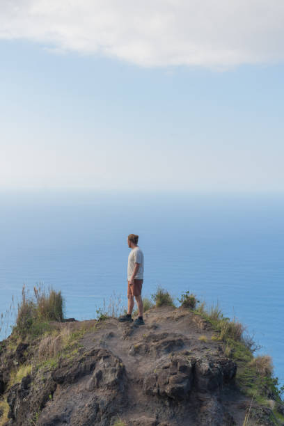 istock Young man hikes to viewpoint over the Pacific Ocean 1385056807
