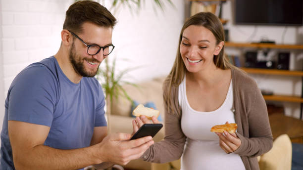 Woman stealing man's breakfast.  Attractive thirties couple.