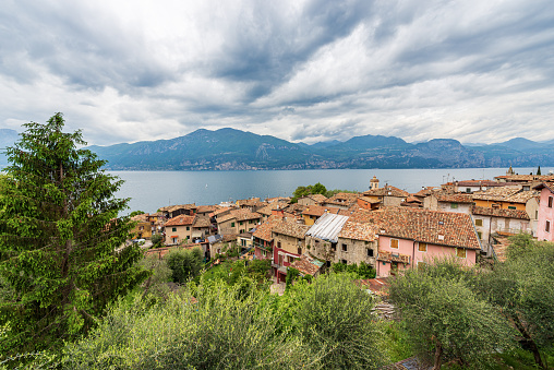 Small village of Castelletto di Brenzone and panoramic view of Lake Garda (Lago di Garda) with the Lombardy coastline on background. Brenzone sul Garda, Verona province, Veneto, Italy, southern Europe