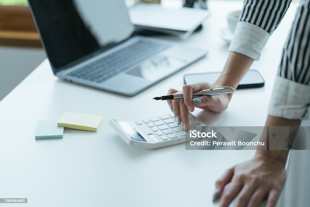 business woman hand calculating her monthly expenses during tax season. business financial and investment concept. Calculator Stock Photo