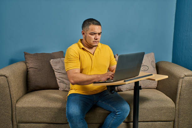 Hispanic Latino man working from home and getting ready on his computer stock photo