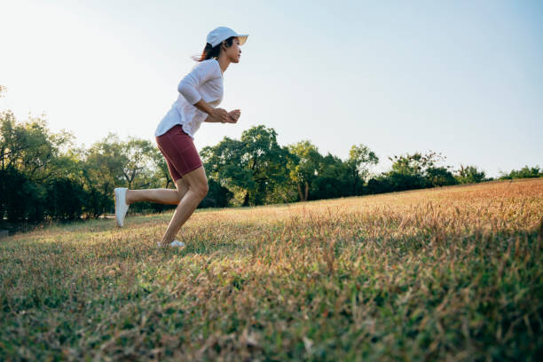 istock Asian female athlete training exercise on grass 1385065134