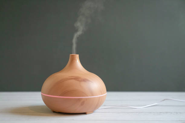 Aroma oil diffuser on table. Aroma essential oil diffuser on table. Grey background, copy space. home diffuser stock pictures, royalty-free photos & images