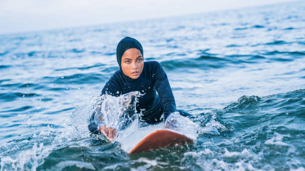 istock Female surfer with hijab in sea 1385065541