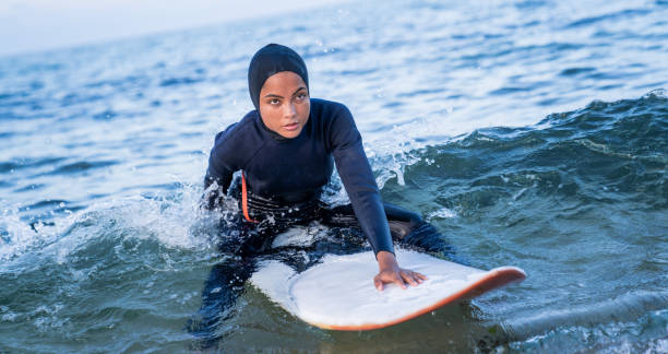 istock Female surfer with hijab in sea 1385065545