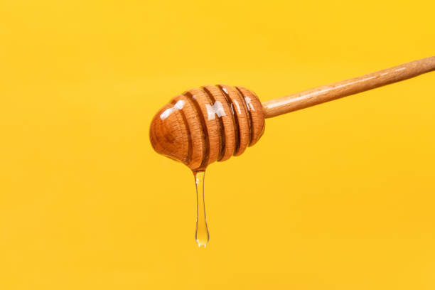 istock honey dripping from a wooden dipper 1385067272