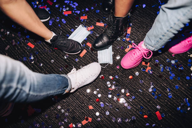 istock Unrecognizable people stepping on face masks and confetti 1385070078