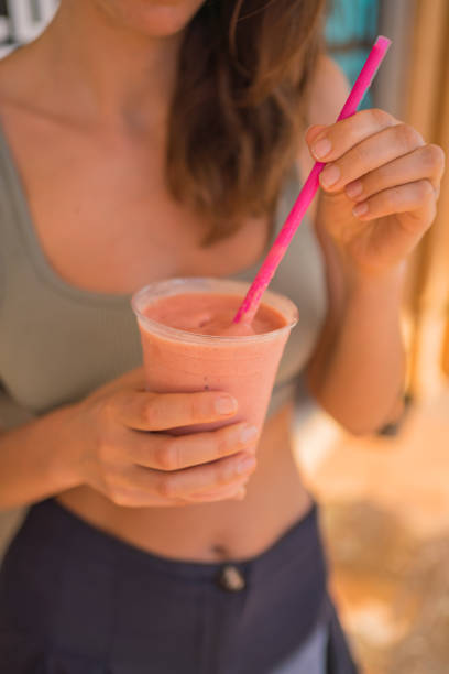 Young woman enjoys the tropical snack in sunshine