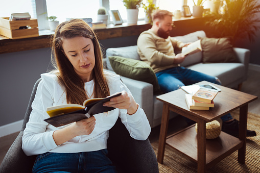 Delighted young female person holding book in both hands