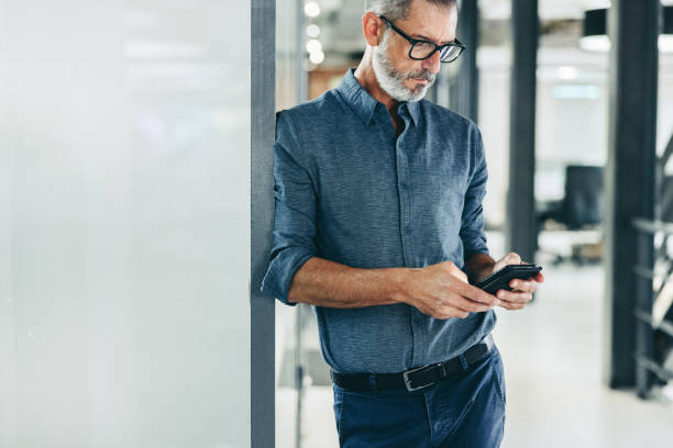 istock Creative businessman sending a text message in an office 1385074898