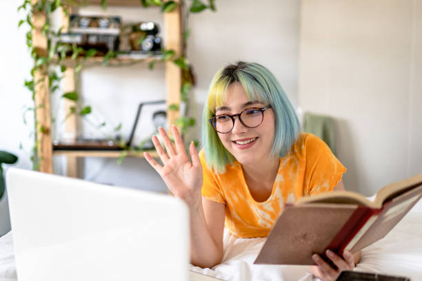 Young woman with colored hair joins online book group stock photo