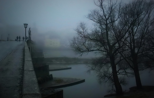 The stone bridge of Regensburg (Steinerne Brücke) over Danube river  on a fogy winter day, Germany