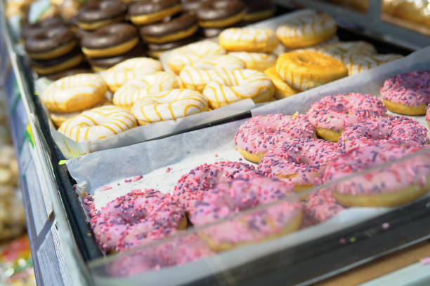 istock Sweet fresh donuts with icing lie on the shelf in the bakery. 1385077720