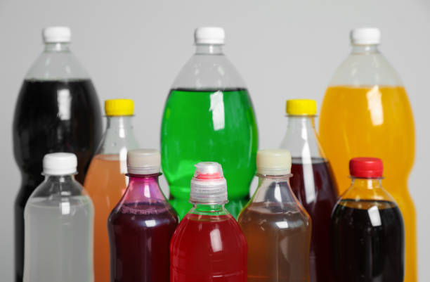 istock Bottles of soft drinks on grey background, closeup 1385080175