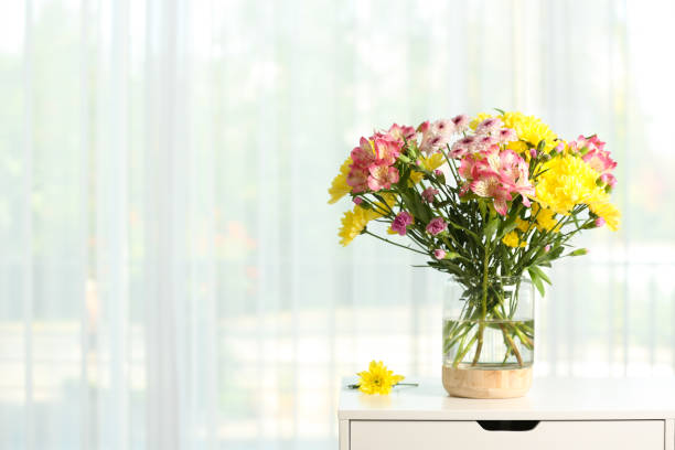istock Vase with beautiful flowers on table near window indoors, space for text. Stylish element of interior design 1385080207