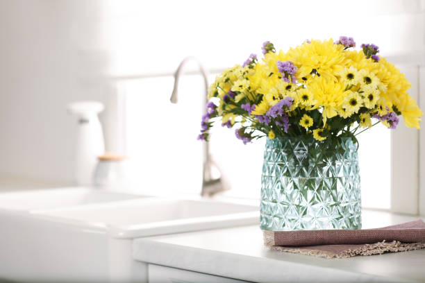 istock Vase with beautiful chrysanthemum flowers on countertop in kitchen, space for text. Interior design 1385080334