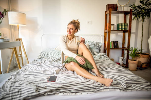relaksujący poranek w domu - waking up women bedding underwear zdjęcia i obrazy z banku zdjęć