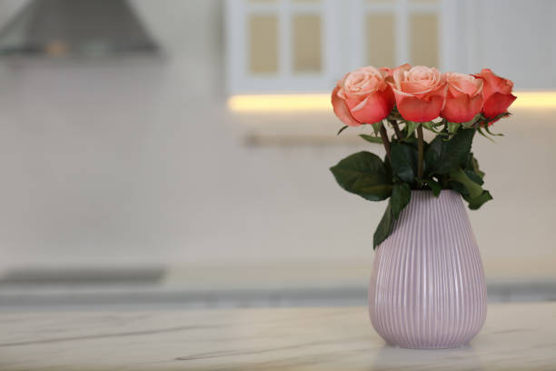 istock Vase with beautiful roses on white marble kitchen table, space for text. Interior design 1385080560
