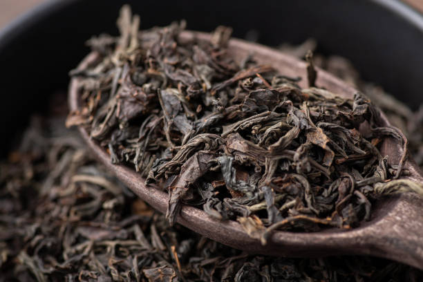istock Black tea in wooden spoon in bowl 1385083722