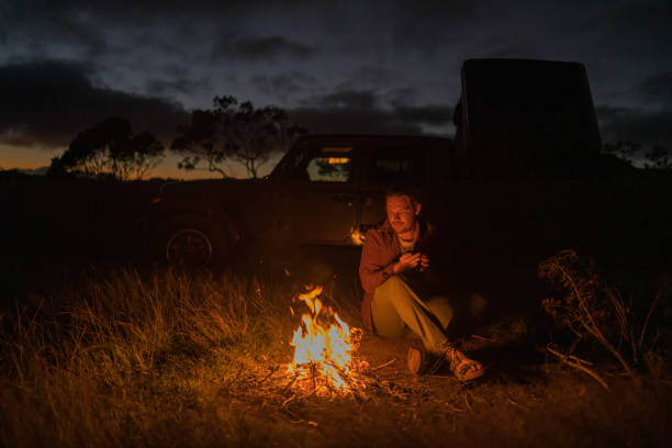 istock Young woman relaxes by campfire 1385084995