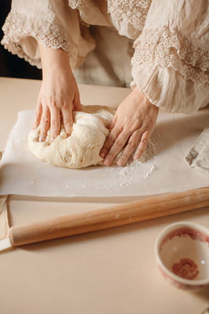 istock female hands knead the dough on a light background 1385085750