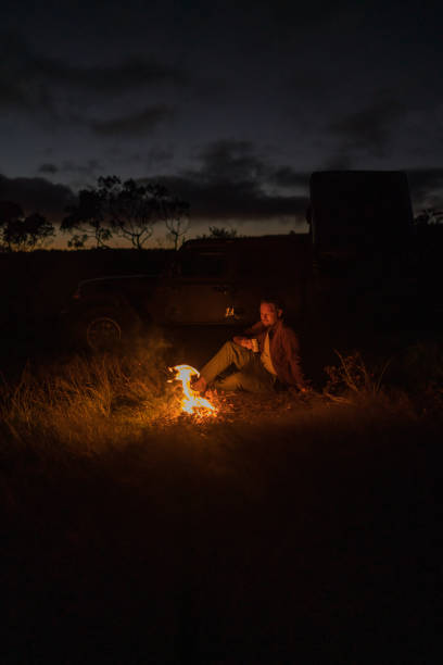 istock Young woman relaxes by campfire 1385085872