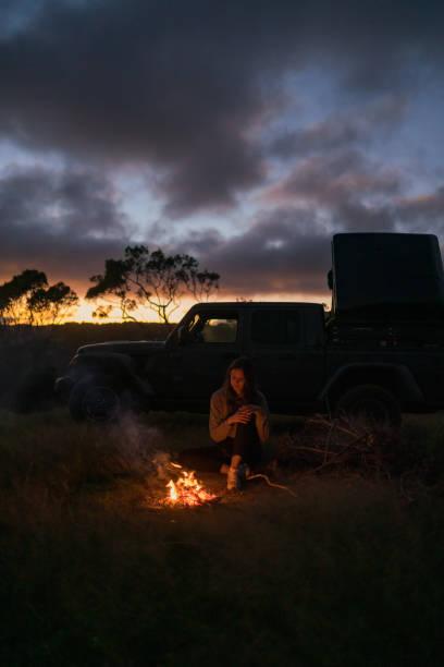 istock Young woman relaxes by campfire 1385085876