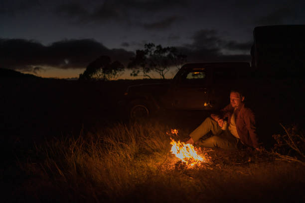 istock Young woman relaxes by campfire 1385085911