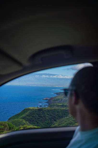 istock Young man on holiday drives car down coastal road 1385086385