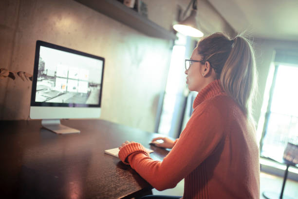 istock A female programmer with her back to the camera sits at a desk and works on a computer in her home office during the day. 1385087658