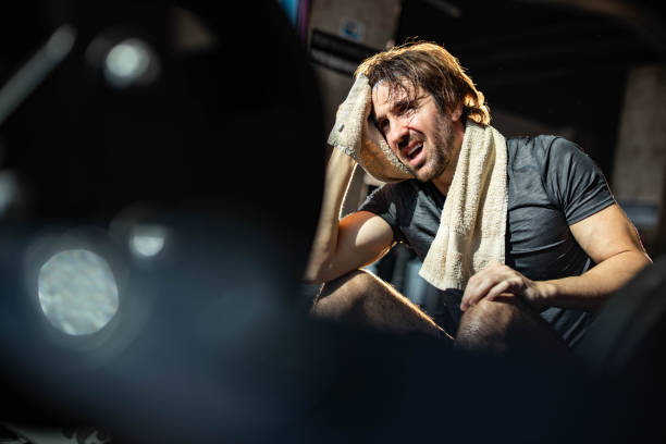 istock Exhausted athletic man taking a break in a gym. 1385089109