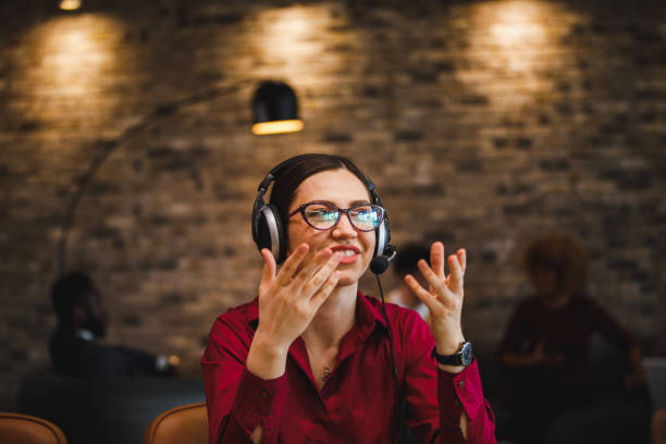 istock Confident young woman wearing a headset, talking with a customer, gesturing a solution 1385089517