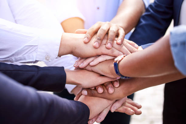 istock Shot of a group of unrecognizable people stacking their hands outside 1385090181