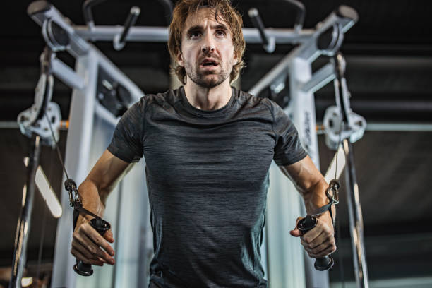 istock Determined athletic man exercising on a machine in a gym. 1385090204