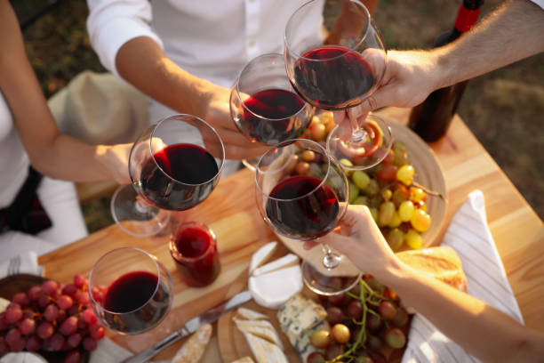 amigos sosteniendo copas de vino en la mesa, primer plano - wineyard fotografías e imágenes de stock